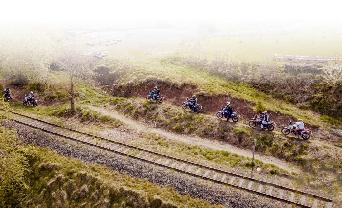 Mehrere Motorradfahrer auf dem Trainingsgelände neben Bahnschiene